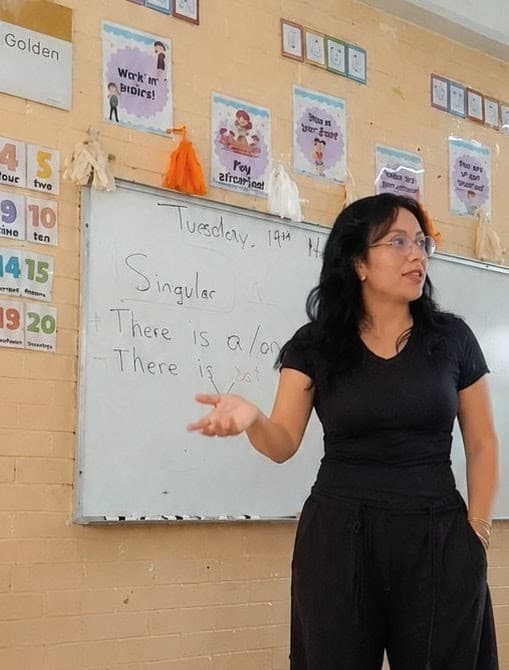 Eréndira Acosta Mejía dando clase frente a un pizarrón
